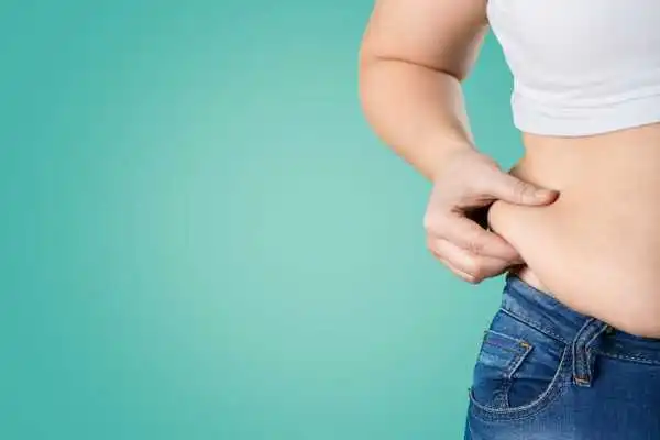 Image of woman pinching her love handles to show weight gain Wilmslow